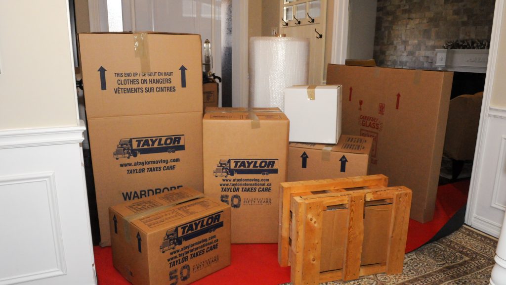 Pile of moving boxes with Taylor Moving logo on them