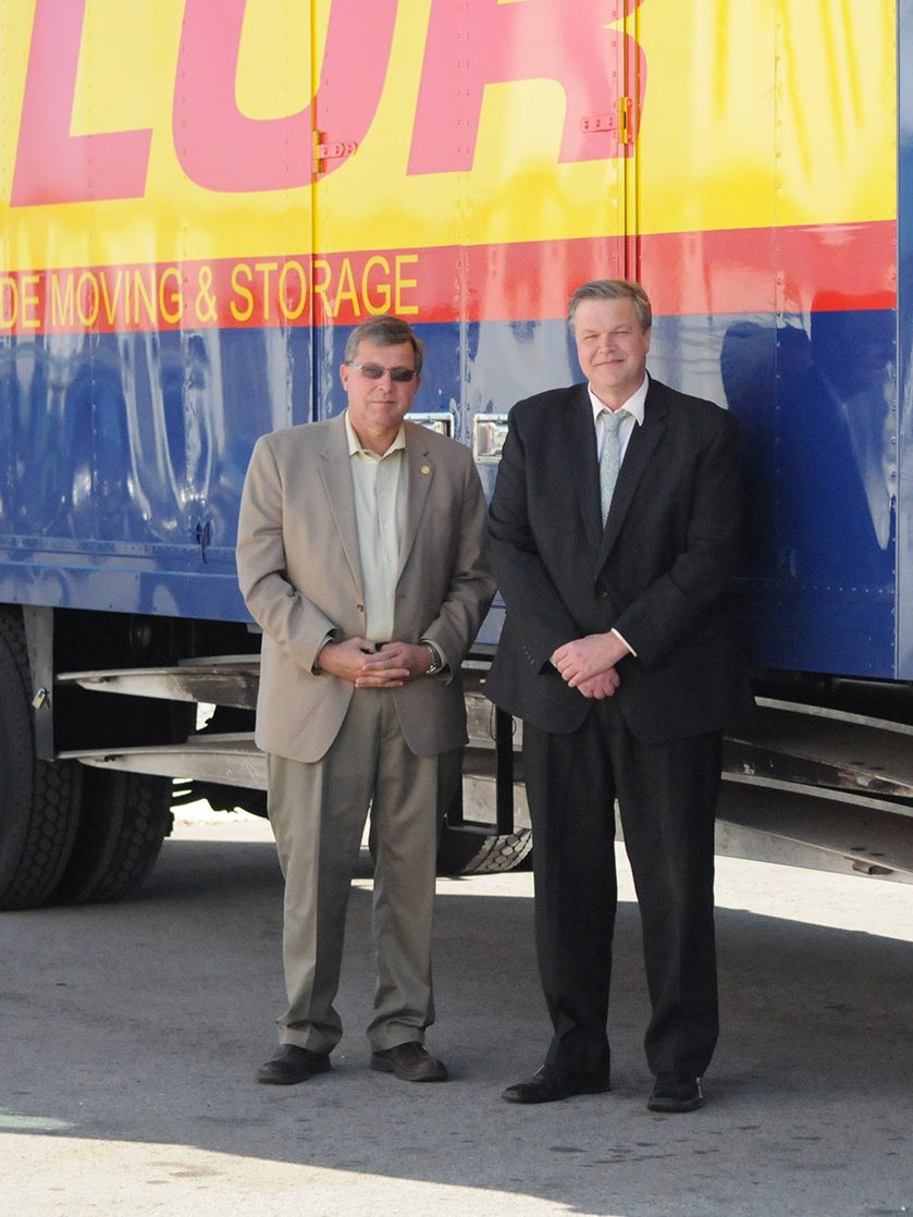 Rick and Russ Taylor standing next to a Taylor Moving truck