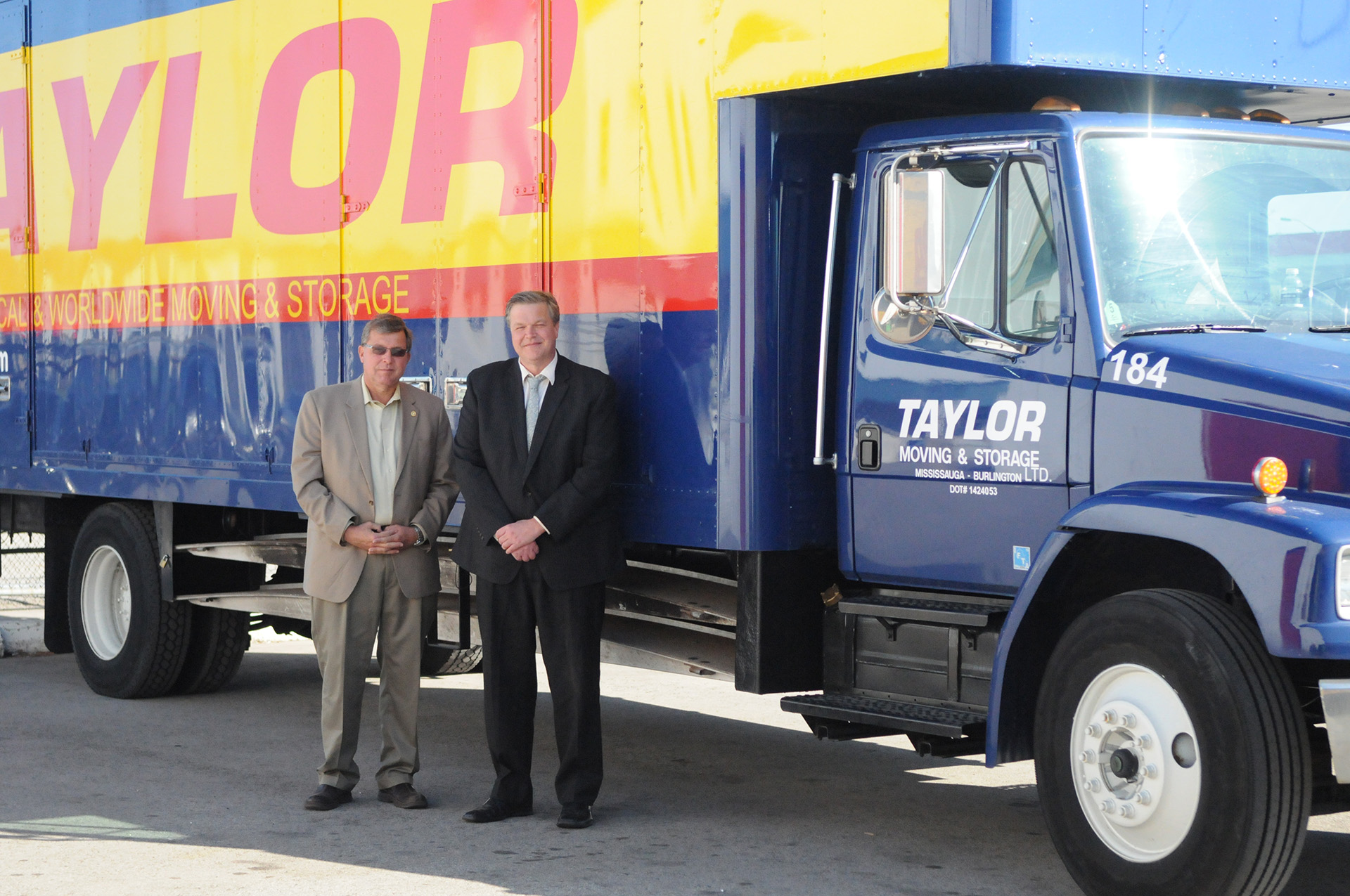 Rick and Russ Taylor standing next to a Taylor Moving truck