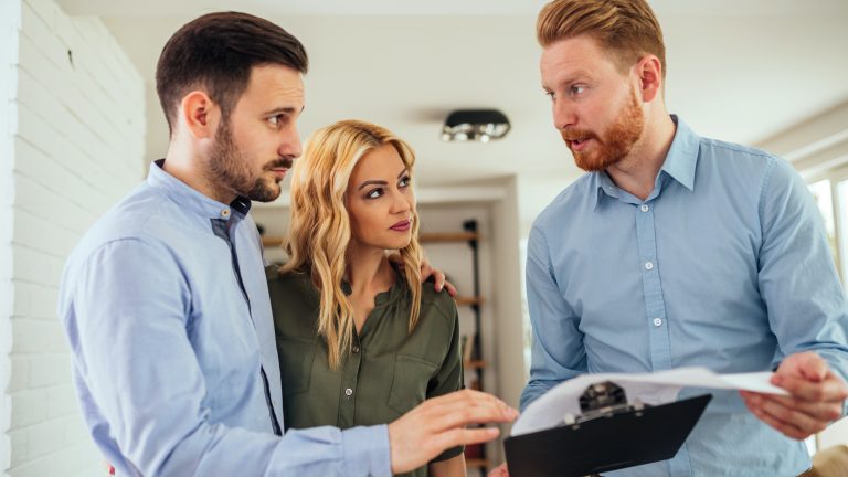 Man showing a couple information an a clipboard