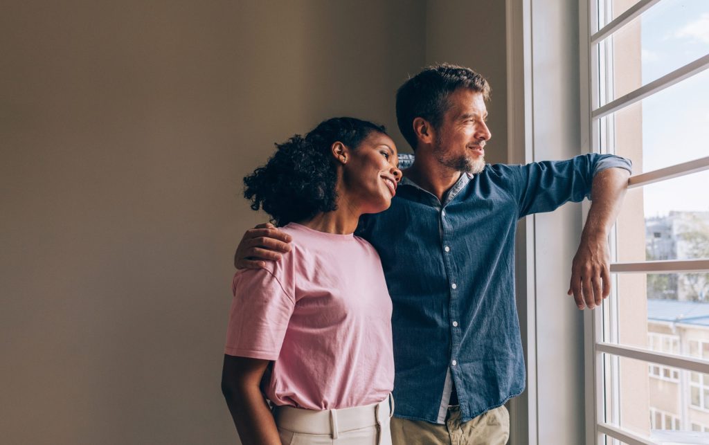 Man and woman looking through a window in a new home