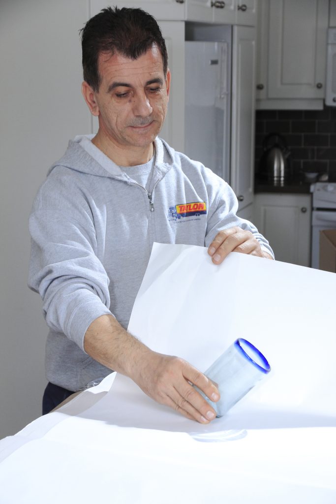 Man wrapping a glass in paper