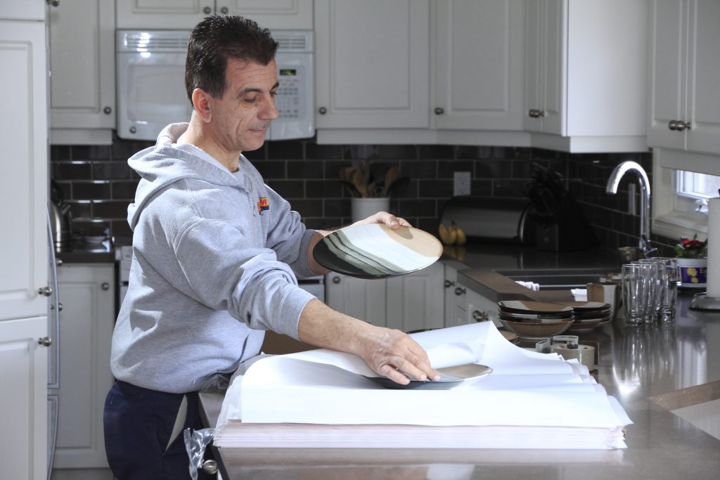 Man wrapping plate in paper