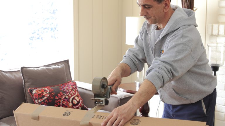 Man taping a moving box