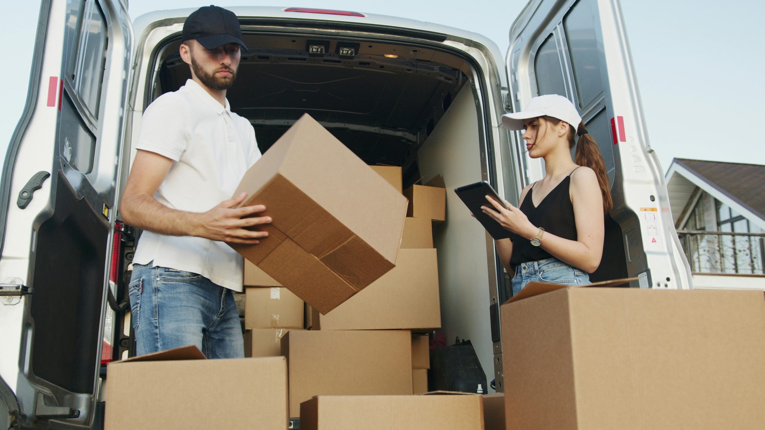 A man and woman placing boxes in a moving truck