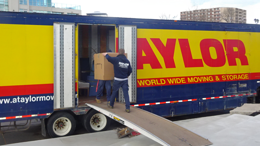 Movers loading boxes on Taylor moving truck